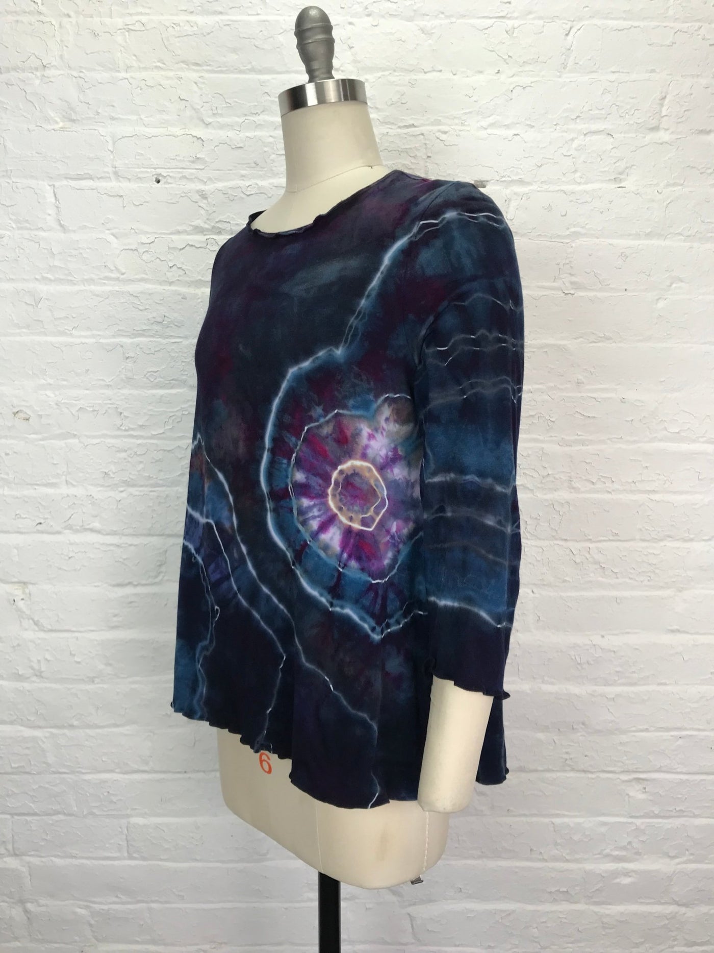 Long sleeve hand-dyed bamboo/cotton jersey tee with a flared fit, featuring bold spiral and lightning designs in deep indigo, violet, magenta, and pale blue.