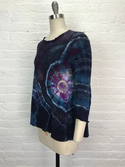 Long sleeve hand-dyed bamboo/cotton jersey tee with a flared fit, featuring bold spiral and lightning designs in deep indigo, violet, magenta, and pale blue.