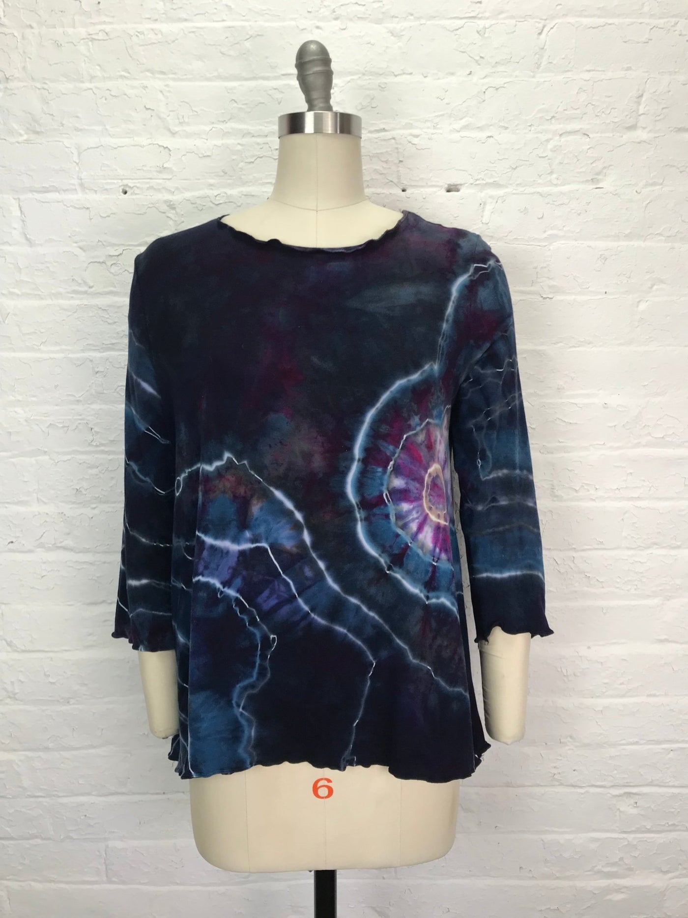 Long sleeve hand-dyed bamboo/cotton jersey tee with a flared fit, featuring bold spiral and lightning designs in deep indigo, violet, magenta, and pale blue.