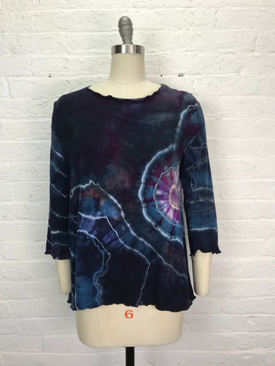 Long sleeve hand-dyed bamboo/cotton jersey tee with a flared fit, featuring bold spiral and lightning designs in deep indigo, violet, magenta, and pale blue.