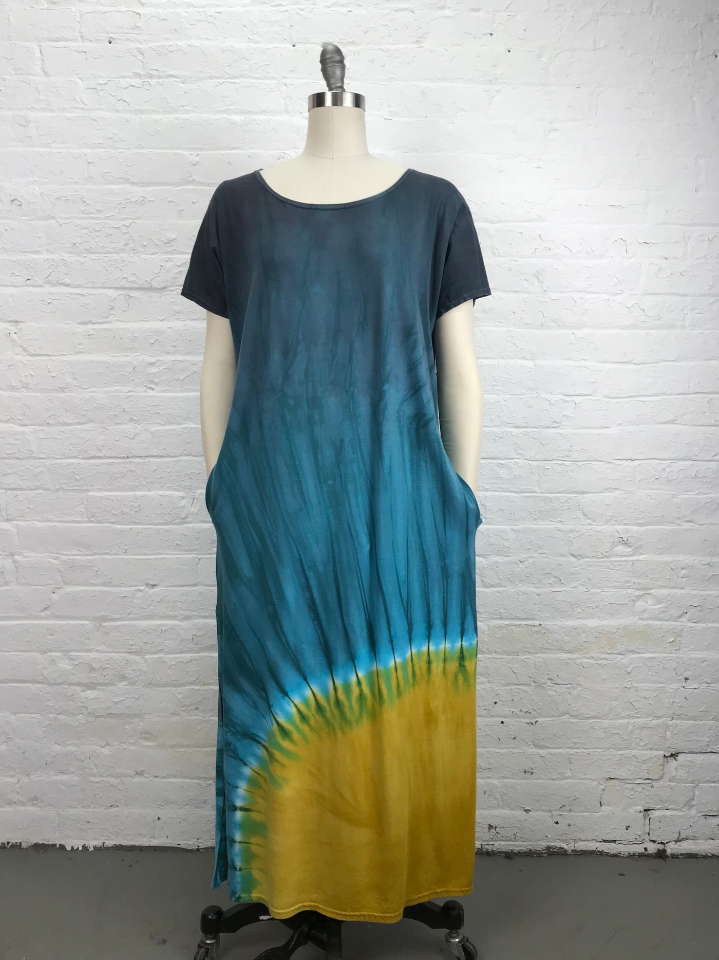 The Astrid Maxi Dress in Sunshine is hand dyed in a brightly patterned in gold and turquoise ombre